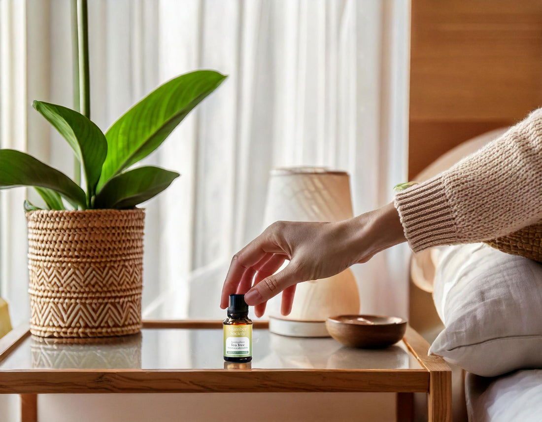 A hand picking up a bottle of essential oil on the bedside