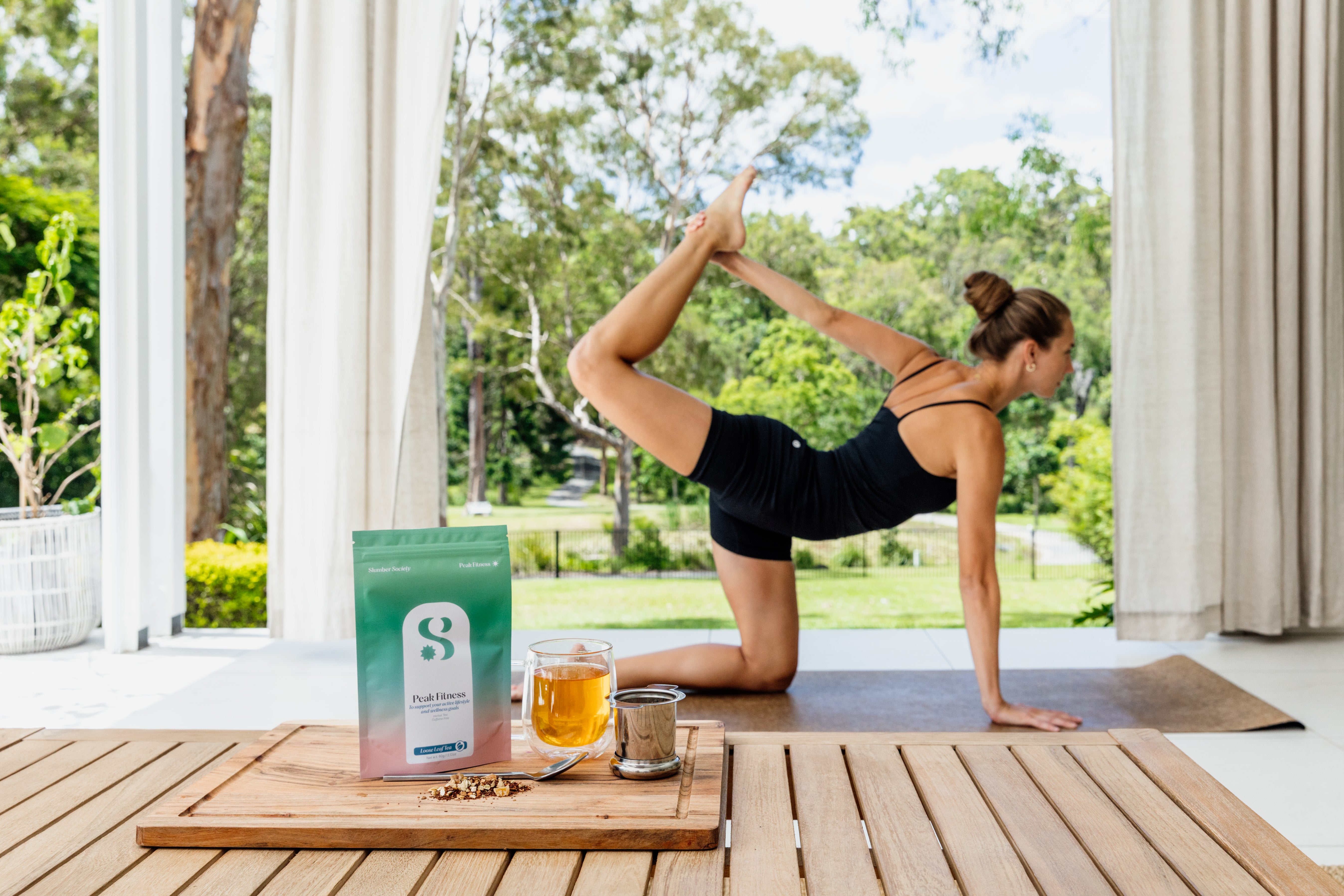 Model doing yoga with Peak Fitness Loose Leaf tea in front showcasing health benefits of the the Tea.